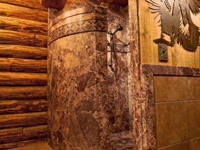 A bathroom remodel with a stone wall and a wooden shower. - bathroom remodeling and renovation from Oasis Bath Solutions of Kent Washington