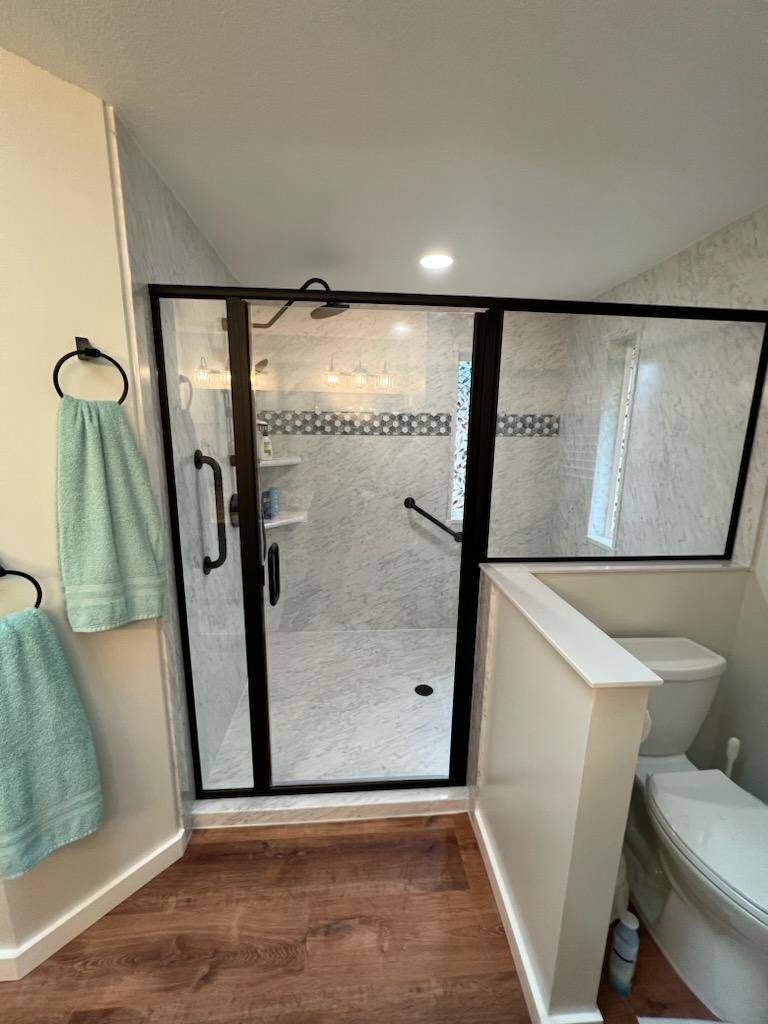 A bathroom with a glass shower stall and toilet - bathroom remodeling and renovation from Oasis Bath Solutions of Kent Washington