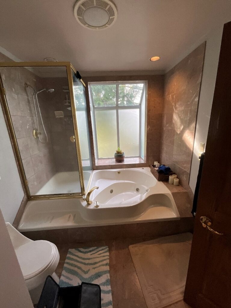 An interior bathroom featuring a large bathtub with jets, sentrel bath walls, and frosted glass windows. Bathroom remodeling and renovation from Oasis Bath Solutions of Kent Washington